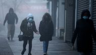 Pedestrians, some wearing a face mask or covering due to the COVID-19 pandemic, walk in the early morning fog in Walthamstow, east London on November 27, 2020. AFP / Tolga Akmen