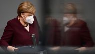 German Chancellor Angela Merkel is reflected as she wears a face mask before holding her speech during a session at the Bundestag (lower house of parliament) on November 26, 2020 in Berlin on measures to curb the spread of the novel coronavirus (COVID-19)