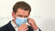 Austria's Chancellor Sebastian Kurz takes of his mask as he arrives to a news conference, as the spread of the coronavirus disease (COVID-19) continues, in Vienna, Austria November 25, 2020. REUTERS/Leonhard Foeger