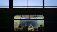 Passengers wearing face masks to protect against the coronavirus disease ride on a metro train in Moscow on November 30, 2020. / AFP / Natalia KOLESNIKOVA