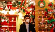 A man wearing a protective mask looks on inside a shop on the day Italian Health Minister Roberto Speranza lays out in parliament the government's plan for mass coronavirus disease (COVID-19) vaccinations and restrictions over the Christmas period, in Rom