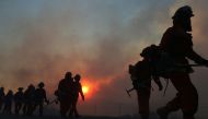 IRVINE CALIFORNIA - DECEMBER 03: Inmate firefighters work as the Bond Fire burns shortly after sunrise in the Silverado Canyon area of Orange County on December 3, 2020 near Irvine, California. The 4,000-acre wildfire broke out along with a number of othe