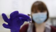 An NHS pharmacy technician holds a vial as she simulates the preparation of the Pfizer-BioNTech coronavirus vaccine, during a staff training session ahead of the vaccine's rollout next week, at the Royal Free Hospital in London on December 4, 2020. / AFP 