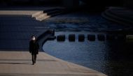 A man wearing a face mask walks alongside the Chongye stream in central Seoul on December 4, 2020. / AFP / Ed JONES