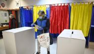 A woman votes at a polling station in Bucharest during the parliamentary elections on December 6, 2020.  AFP / Daniel MIHAILESCU