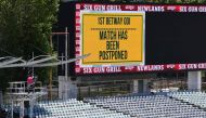 Empty stands and a message of the match postponement on the screen are seen at Newlands stadium in Cape Town, South Africa, on December 4, 2020. / AFP / Rodger BOSCH
