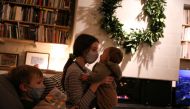 Jane Hassebroek holds her cousin while sitting next to her brother Felix, as the global outbreak of the coronavirus disease (COVID-19) continues, in New York City, U.S., December 6, 2020. REUTERS/Caitlin Ochs