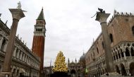 A view shows a flooded St. Mark's Square with the Doge's Palace (R), the Bell Tower (Rear L), St. Mark's Basilica (Rear C) and a luminous Christmas Tree installation by Italian artist Fabrizio Plessi (Front C) on December 8, 2020 following a high tide 