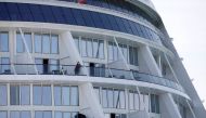 Passengers look from their balconies of the Royal Caribbean's Quantum of the Seas cruise ship, docked at Marina Bay Cruise Center after a passenger tested positive for coronavirus disease (COVID-19) during a cruise to nowhere, in Singapore, December 9, 20