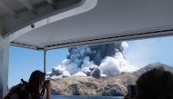 This handout file photograph released courtesy of Michael Schade and taken on December 9, 2019 shows the volcano on New Zealand's White Island spewing steam and ash moments after it erupted. AFP Photo/ Courtesy of Michael Schade 