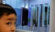 A boy looks at an ultraviolet sterilising machine cleaning library books he rents, amid the coronavirus disease (COVID-19) outbreak, at Narimasu library in Itabashi district in Tokyo, Japan, December 9, 2020. REUTERS/Kim Kyung-Hoon