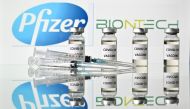 (FILES) This file illustration taken on November 17, 2020, in London shows vials with Covid-19 vaccine stickers attached and syringes with the logo of US pharmaceutical company Pfizer and German partner BioNTech. Canada on December 9, 2020, approved the P