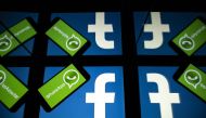 (FILES) In this file photo taken on October 05, 2020 the logo of US social network Facebook and mobile messaging service WhatsApp are seen on the screens of a smartphone and a tablet in Toulouse, southwestern France. US federal and state antitrust enforce