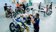 Riders are seen tending to their bikes on the second day of the installation of navigation kits for the motorcycle category as part of the Qatar National Baja events. 