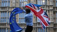 In this file photo taken on June 28, 2016, A man waves both a Union flag and a European flag together on College Green outside The Houses of Parliament at an anti-Brexit protest in central London.  AFP / Justin Tallis 