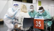 Medical personnel swabs the throat of a patient as he administers a COVID-19 test on December 12, 2020, at the exhibition hall in Graz. Mass detection tests will be held in Styria on December 12 and 13, 2020.  AFP /  ERWIN SCHERIAU