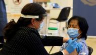 A healthcare worker administers a Pfizer/BioNTEch coronavirus disease (COVID-19) vaccine to personal support worker Anita Quidangen at The Michener Institute, in Toronto, Canada December 14, 2020. REUTERS/Carlos Osorio