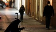 A woman begs for money near Spanish Steps as the government prepares to bring in further restrictions over the Christmas period during the spread of the coronavirus disease (COVID-19) in Rome, Italy December 14, 2020. REUTERS/Yara Nardi