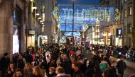 Christmas illuminations are seen above shoppers on Regent Street in the main high-street shopping area of London on December 15, 2020 ahead of fresh measures for the capital amid rising novel coronavirus infection rates. AFP / DANIEL LEAL-OLIVAS