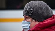 A woman wearing a face mask to protect against the coronavirus disease walks along a street in the town of Chekhov, some 70 km outside Moscow, on December 21, 2020. / AFP / Yuri KADOBNOV