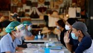 Migrant workers talk with the public health authorities for a COVID-19 investigation at a fresh market, amid the coronavirus disease (COVID-19) outbreak, in Bangkok, Thailand, December 22, 2020. REUTERS/Chalinee Thirasupa