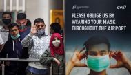 People wearing protective face masks wait for passengers to arrive at Chhatrapati Shivaji Maharaj International Airport after India cancelled all flights from the UK over fears of a new strain of the coronavirus disease (COVID-19), in Mumbai, India, Decem