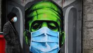 A man walks past a graffiti of a Frankenstein wearing a protective face mask on a doorway amid the spread of the coronavirus disease (COVID-19) pandemic, in Galway, Ireland, December 22, 2020. REUTERS/Clodagh Kilcoyne
