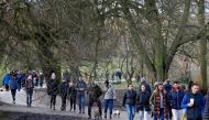 Members of the public enjoy a stroll on Hampstead Heath in London on December 27, 2020, as Londoners continue to live under Tier 4 lockdown restrictions. (AFP / Tolga Akmen)