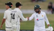 Pakistan’s Faheem Ashraf touches fist with New Zealand’s Mitchell Santner (2nd L) on day three of the first cricket Test match between New Zealand and Pakistan at the Bay Oval in Mount Maunganui on December 28, 2020. / AFP / MICHAEL BRADLEY
