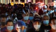 People wearing face masks and face shields as protection against the coronavirus disease (COVID-19) queue at a bus stop, in Quezon City, Metro Manila, Philippines, December 23, 2020. REUTERS/Lisa Marie David