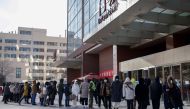Residents wearing face masks wait in a queue to be tested for the Covid-19 coronavirus in Beijing on December 29, 2020. / AFP / Noel Celis