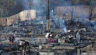 Syrian refugees salvage belongings from the wreckage of their shelters at a camp set on fire overnight in the northern Lebanese town of Bhanine on December 27, 2020, following a fight between members of the camp and a local Lebanese family. AFP / Ibrahim 