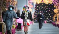 Pedestrians some wearing face masks walk in front of Christmas decorations at a shopping mall in Moscow on December 29, 2020, amidst the Covid-19 pandemic caused by the novel coronavirus. Russia confirmed 27,002 new daily Covid-19 cases including 5,641 in
