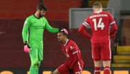Liverpool's Brazilian goalkeeper Alisson Becker (L) stands with injured Liverpool's German-born Cameroonian defender Joel Matip (C) during the English Premier League football match between Liverpool and West Bromwich Albion at Anfield in Liverpool, north 