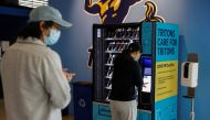 People wearing masks queue up at a vending machine, placed by UC San Diego on campus for students and teachers to self-administer COVID-19 tests, during the outbreak of the coronavirus disease (COVID-19) in San Diego, California, U.S., January 5, 2021. Re