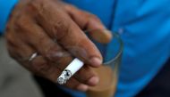 FILE PHOTO: A man smokes a cigarette along a road in Mumbai, India, October 26, 2016. REUTERS/Danish Siddiqui