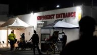 FILE PHOTO: Emergency medical technicians (EMTs) and healthcare workers treat patients outside the emergency room at the Community Hospital of Huntington Park during a surge in positive coronavirus disease (COVID-19) cases in Huntington Park, California, 