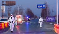 Police officers and staff members in protective suits inspect vehicles at a checkpoint on the borders of Gaocheng district on a provincial highway, following the coronavirus disease (COVID-19) outbreak in Hebei province, China January 5, 2021. Picture tak
