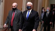 Vice President Mike Pence (R) is escorted by Sgt. at Arms Michael Stenger (L), followed by Senate Majority Leader Mitch McConnell (R-KY) as they walk to the House in the US Capitol to continue a joint session to certify President-elect Joe Biden, in Washi