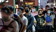 People wearing face masks and face shields as protection against the coronavirus disease (COVID-19) queue at a bus stop, in Quezon City, Metro Manila, Philippines, December 23, 2020. REUTERS/Lisa Marie David/File Photo