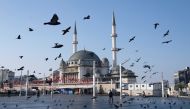 FILE PHOTO: Pigeons fly over the Taksim Square during a nation-wide weekend curfew which was imposed to prevent the spread of the coronavirus disease (COVID-19), in Istanbul, Turkey December 5, 2020. REUTERS/Murad Sezer/File Photo/File Photo
