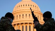 A member of the National Guard is given a weapon before Democrats begin debating one article of impeachment against U.S. President Donald Trump at the U.S. Capitol, in Washington, U.S., January 13, 2021. REUTERS/Joshua Roberts