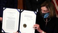 US House Speaker Nancy Pelosi (D-CA) shows the article of impeachment against US President Donald Trump after signing it in an engrossment ceremony, at the US Capitol in Washington January 13, 2021. Reuters/Leah Millis 