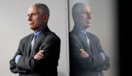FILE PHOTO: National Institute of Allergy and Infectious Diseases Director Dr. Anthony Fauci is reflected in a video monitor behind him on stage as he listens to the daily coronavirus task force briefing at the White House in Washington, U.S., April 8, 20