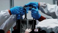 A screen shows footages of researchers holding an equipment carrying lunar sample from Chang'e-5 Mission, during an event on China’s lunar exploration program, at the National Astronomical Observatories of Chinese Academy of Sciences (CAS), in Beijing, Ch