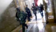 A member of the military rushes past, as people are evacuated back inside after an 