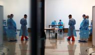 Health workers stand as they wait to take swab samples from young people for a coronavirus disease (COVID-19) antigen test at Rey Juan Carlos University in Mostoles, Spain, January 20, 2021. REUTERS/Sergio Perez
