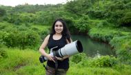 Aishwarya Sridhar, a wildlife photographer, poses with her camera.