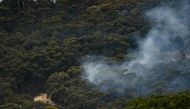 Emergency services can be seen fighting a bushfire that is burning in the Cherry Gardens area in the Adelaide Hills, Australia, January 25, 2021. AAP Image/Morgan Sette/via REUTERS