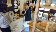 Madoka Uchida sells products by weight at Kanbutsuya Small, a grocery store in Ibaraki, Osaka Prefecture, Japan. Japan News-Yomiuri